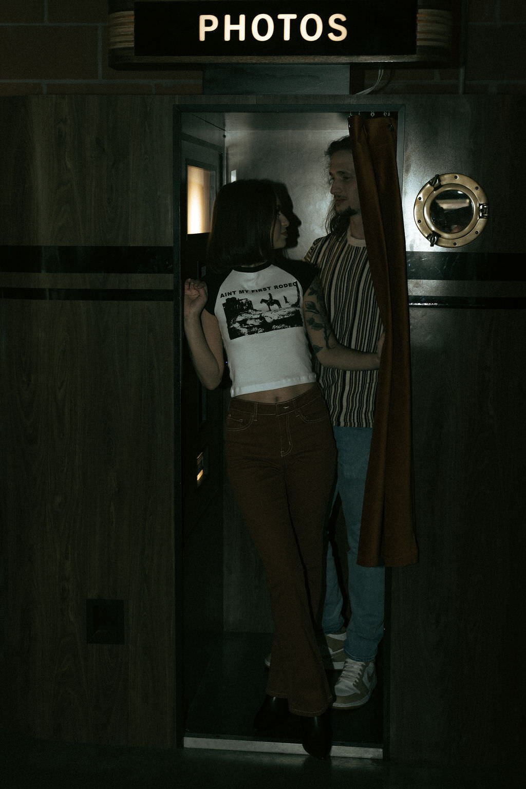 A couple standing in the entrance to a photo booth.