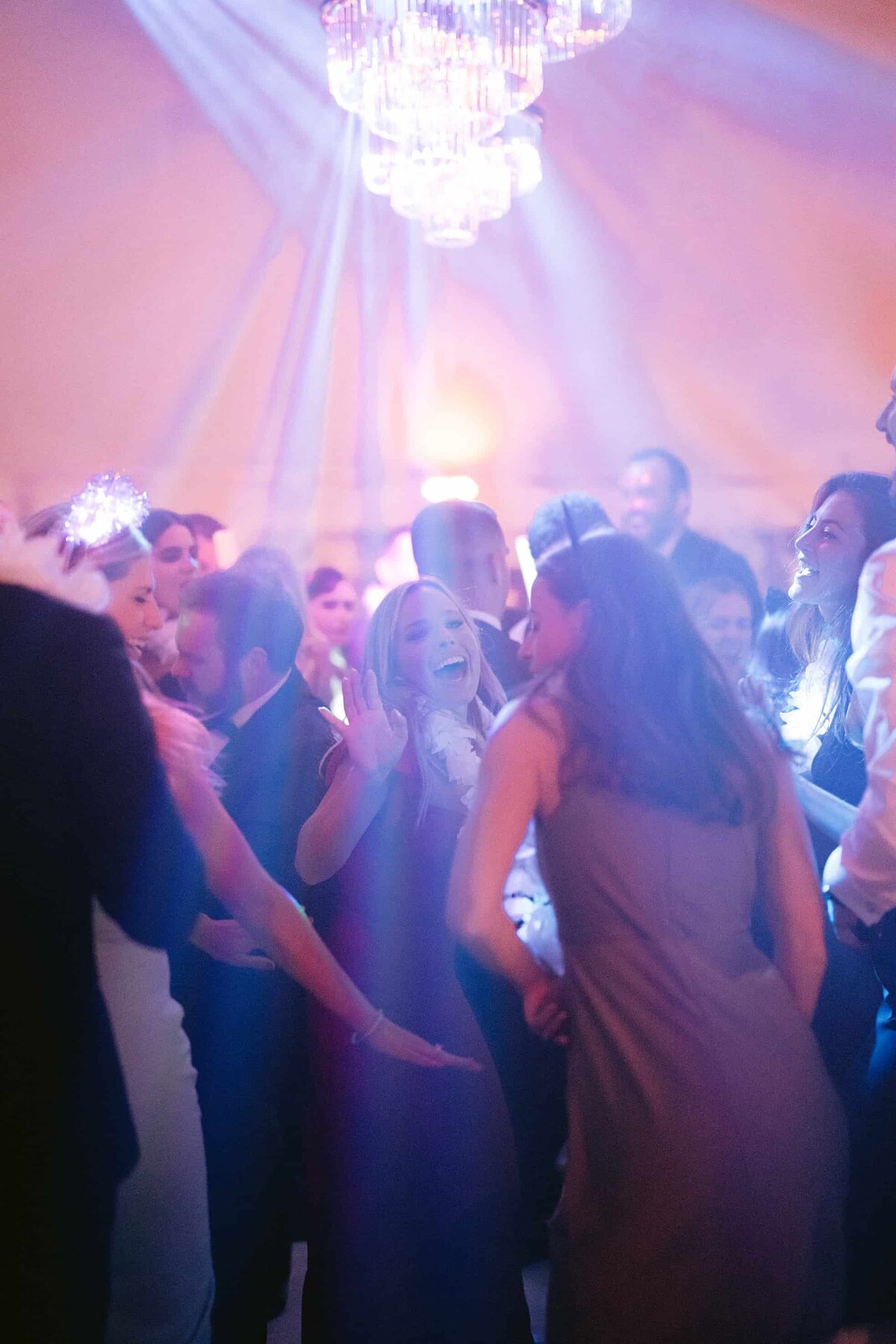 Wedding guests dancing under an event tent