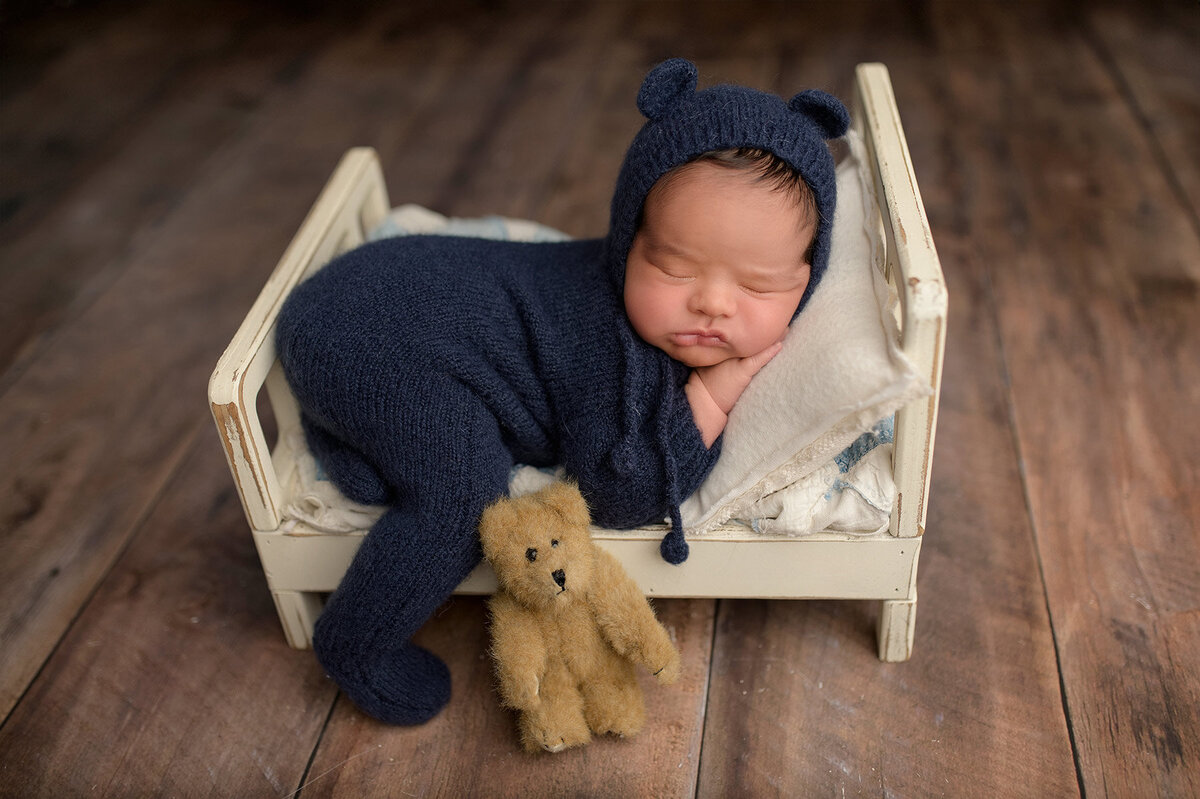 newborn baby sleeping in a tiny bed