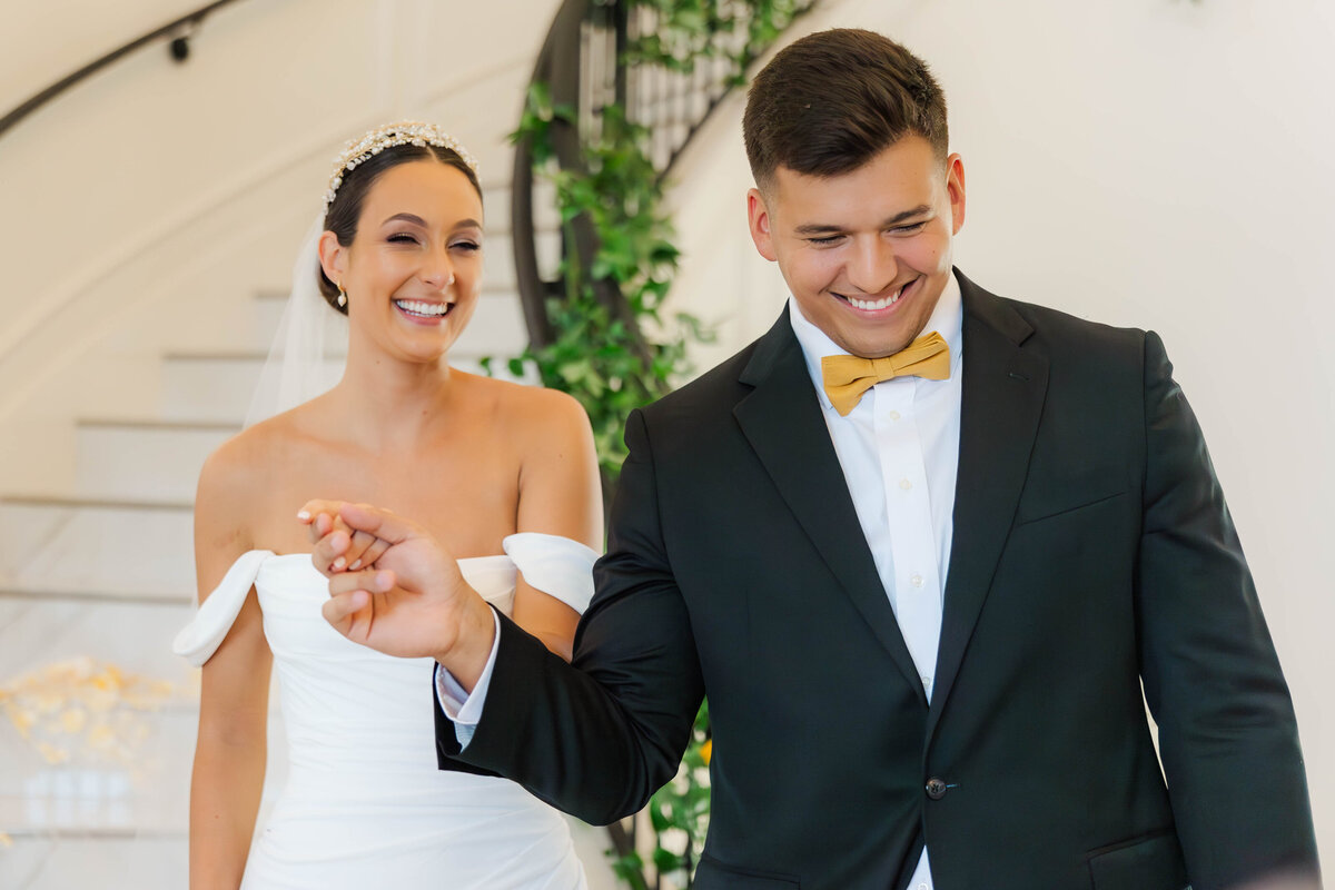Celebrate love with this heartwarming image of a bride and groom sharing a joyful moment. Their radiant smiles and elegant attire create a perfect snapshot of happiness on their special day. Ideal inspiration for capturing candid wedding photography.
