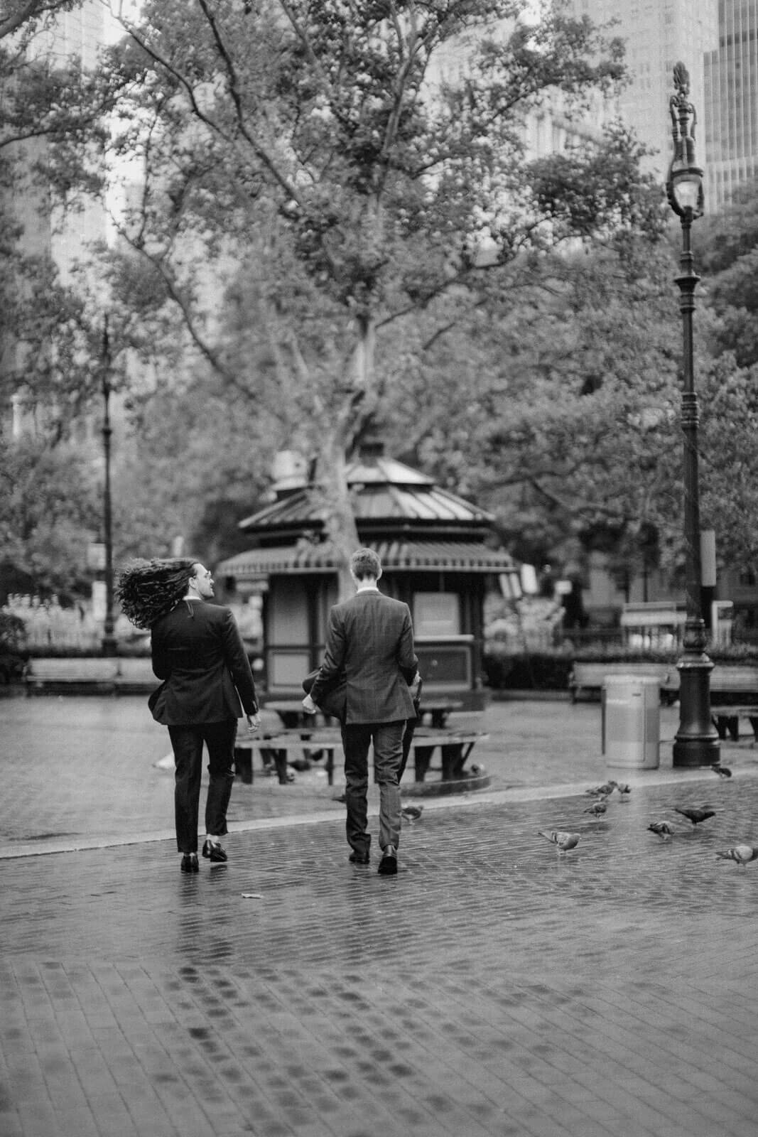 The two grooms are walking towards a park near NYC City Hall. Elopement Image by Jenny Fu Studio