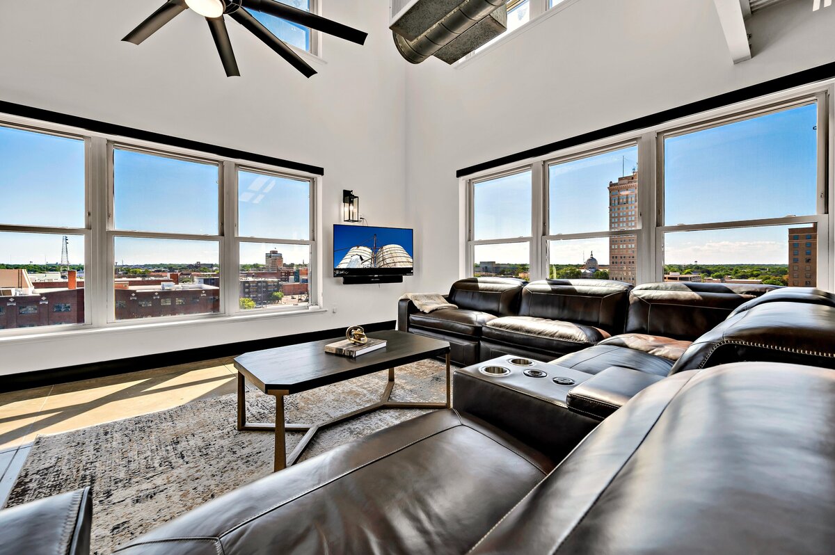 Living room with panoramic view of the city in this two-bedroom, three-bathroom top floor corner loft in the historic Behrens building in downtown Waco, TX