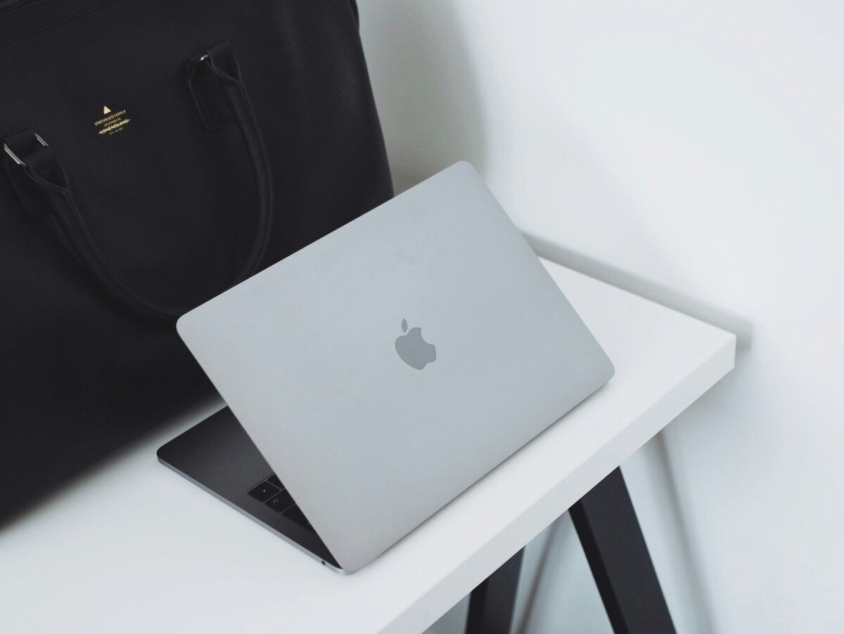 Laptop and handbag on office desk