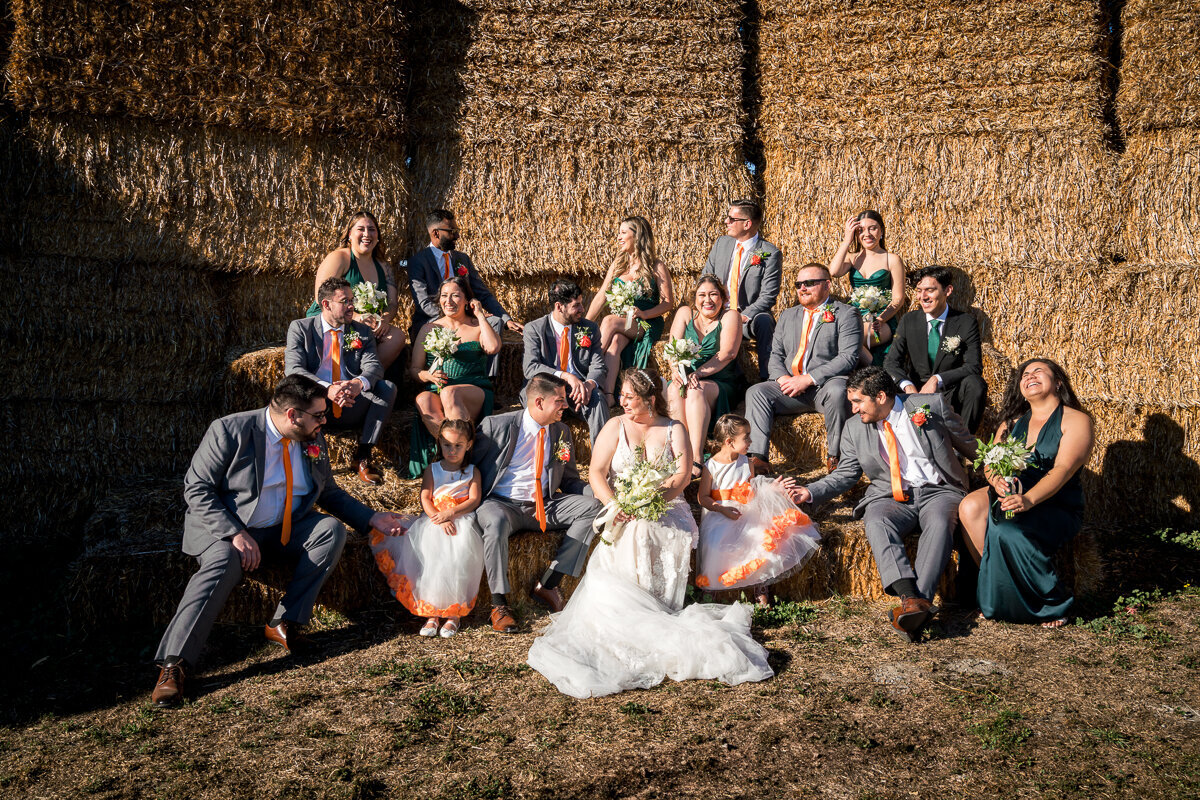 A joyful wedding portrait of the bride and groom with their wedding party at The Barn by Fernbridge, surrounded by rustic charm and celebrating their special day in Northern California.