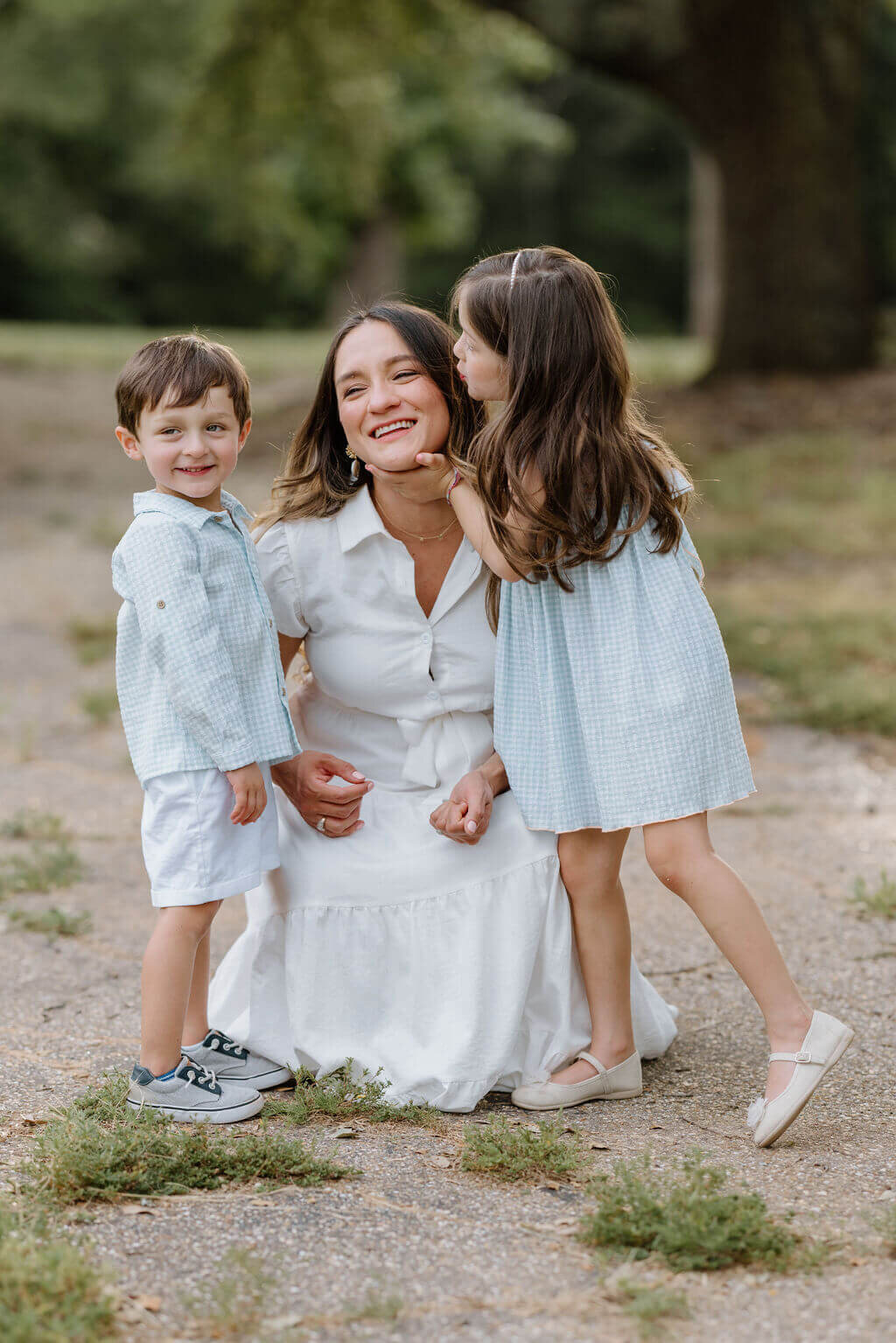 candid moment between young mother and her toddler children during family pictures