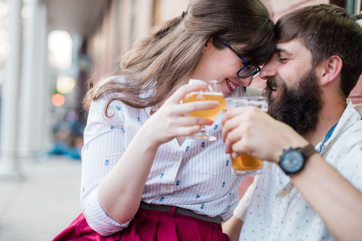 Couple toasting with beer during engagement session at the Holy Hound in York PA