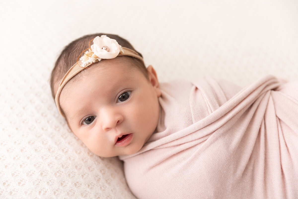 A newborn baby girl in pink photographed by Susan Hennessey Photography, a South Jersey newborn photographer.