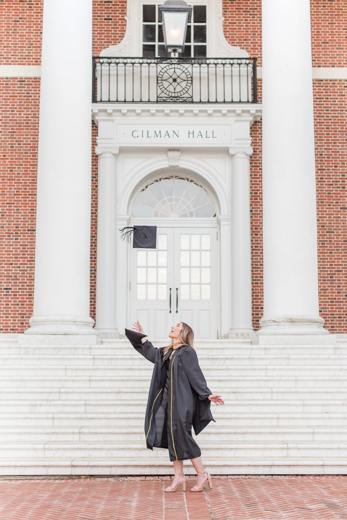 graduate throwing cap at gilman hall jhu