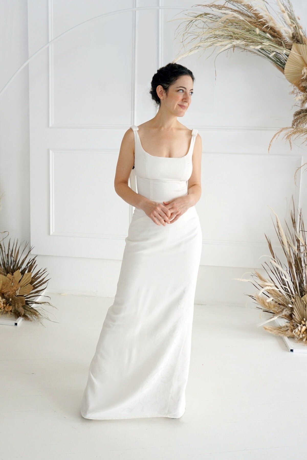 The front of the Jealine floral crepe wedding gown with the detachable trains removed to highlight the column silhouette.