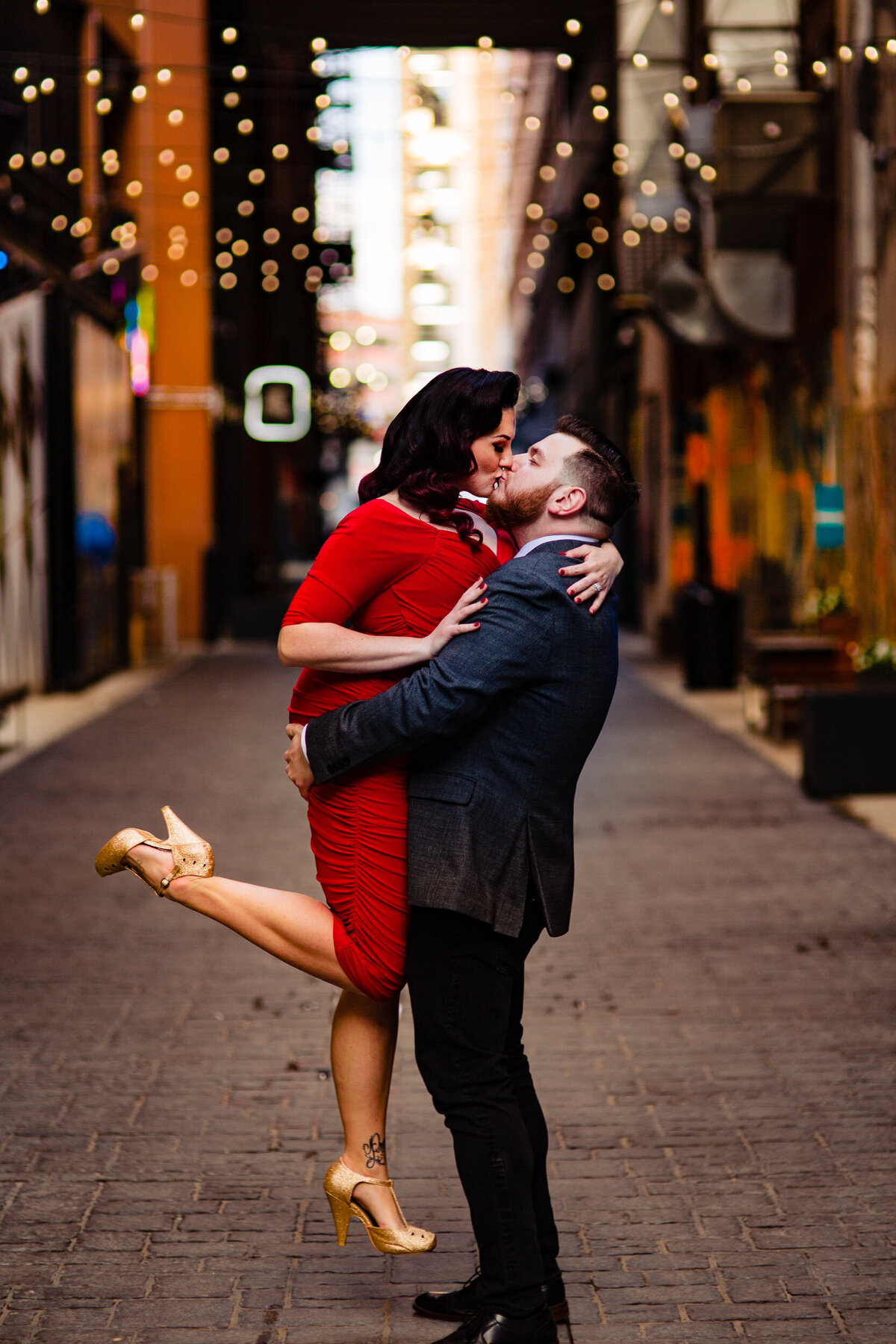 An engagement photo in downtown Detroit Michigan kiss at the Belt under the lights.  Photo By Adore Wedding Photography. Toledo Wedding Photographers