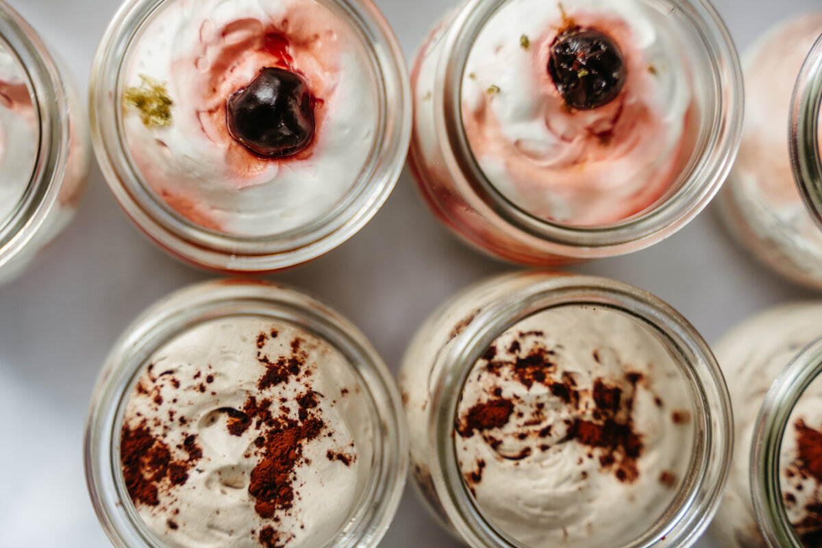 Vegan dessert cups topped with fruit and cream