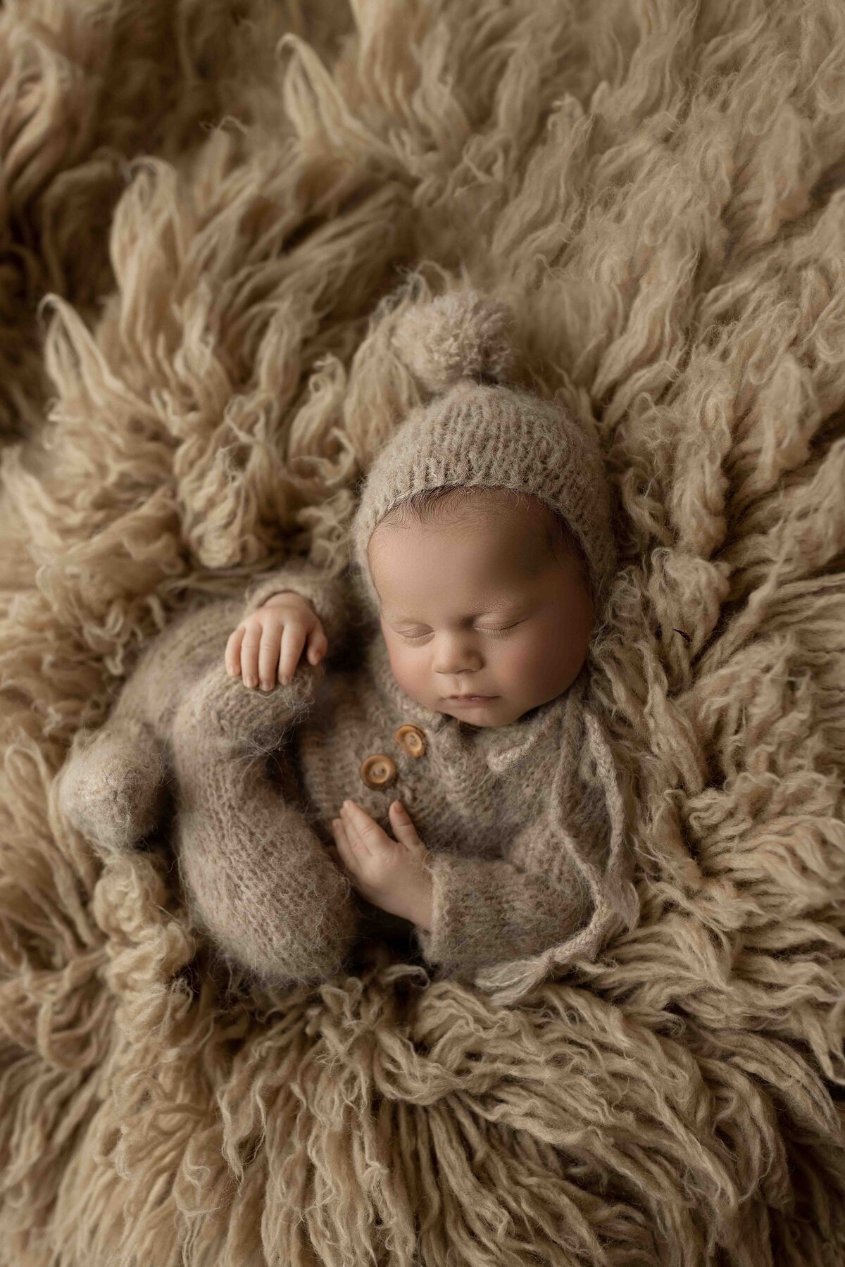 Ogg Photography London, Ontario Newborn Photographer Baby Touching Toes on in Beige Outfit
