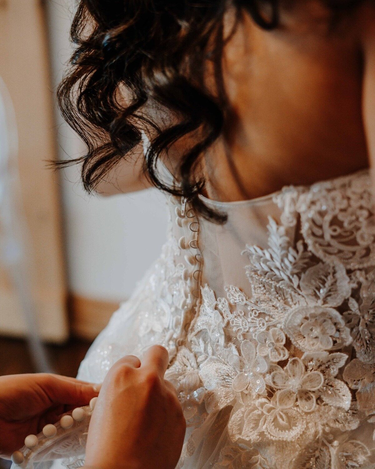 a bride being buttoned up at Chickadee Hill Farms in North Carolina