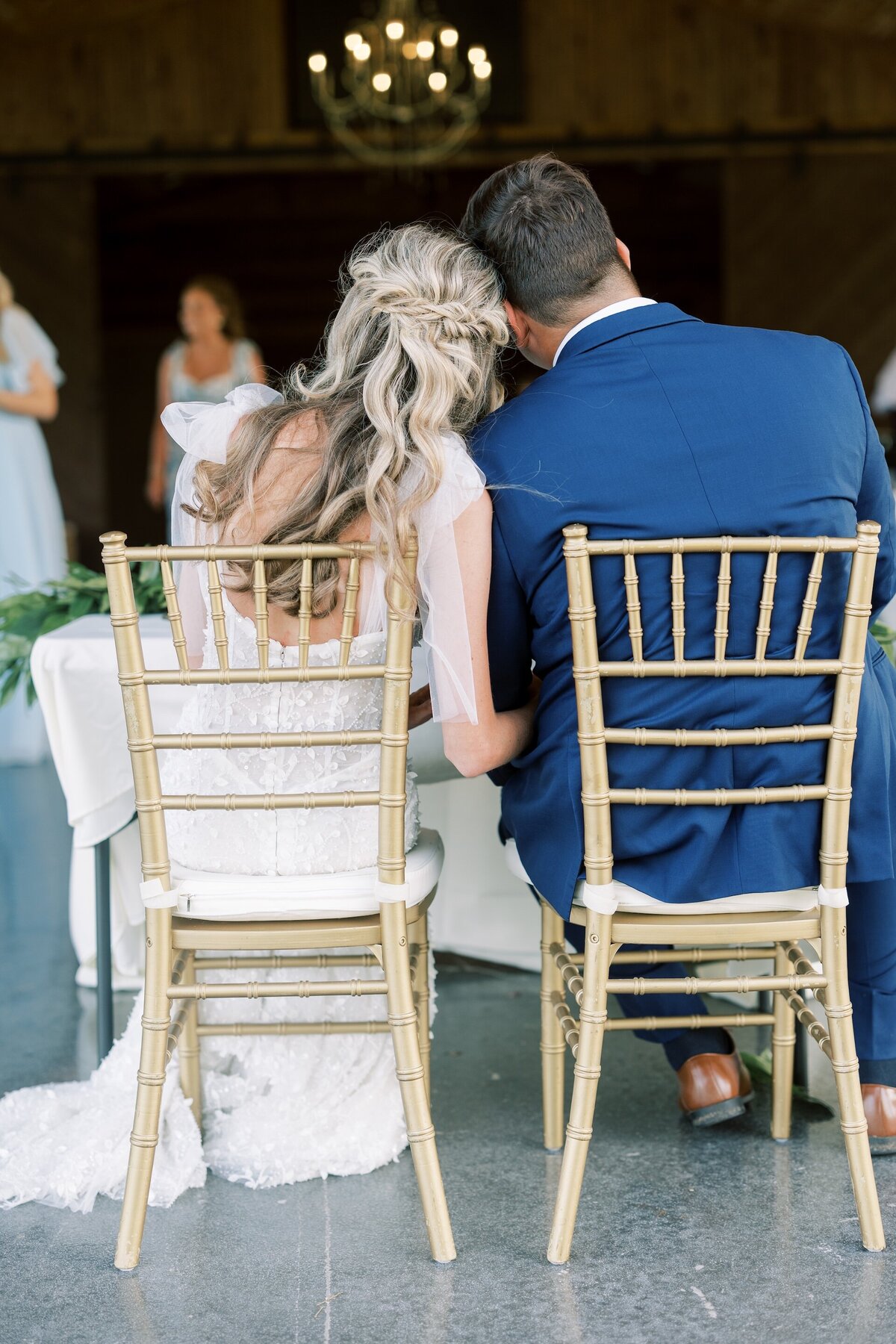bride and groom leaning against each other during a sweet moment at their wedding reception