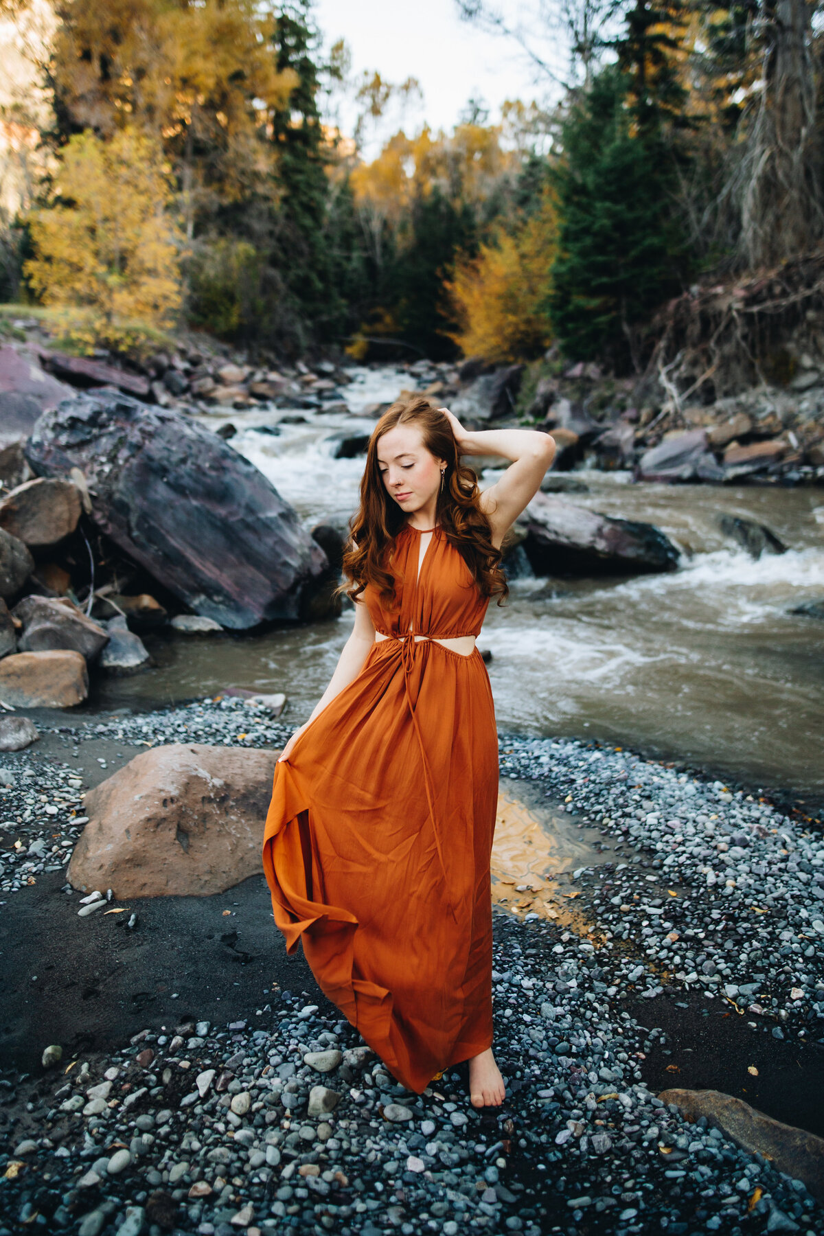 Olivia poses on a riverbank for her Ouray senior pictures.