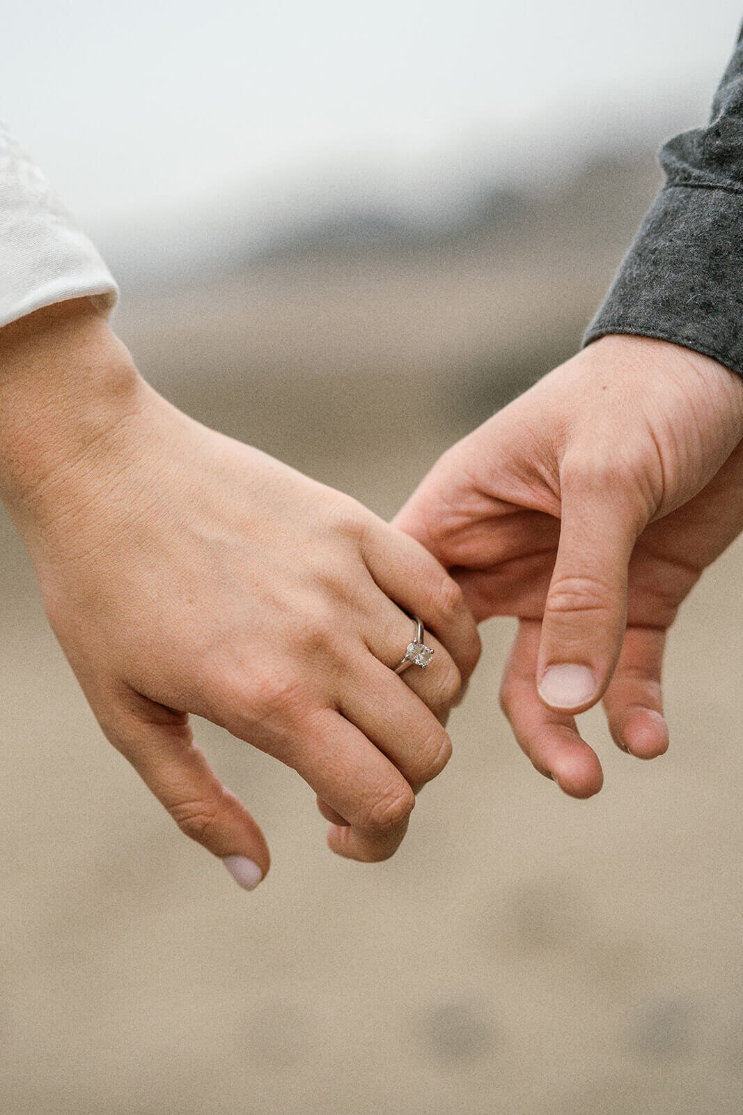 Close up of hands holding at the beach. 