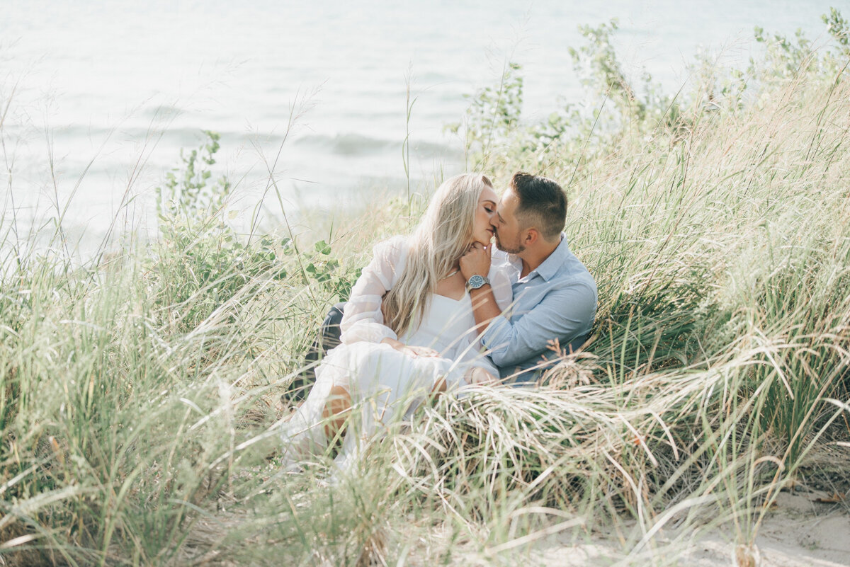 Couple posing for photos on the beach at their Grand Bend Ontario Engagement Photographer NovaMarkina Photography