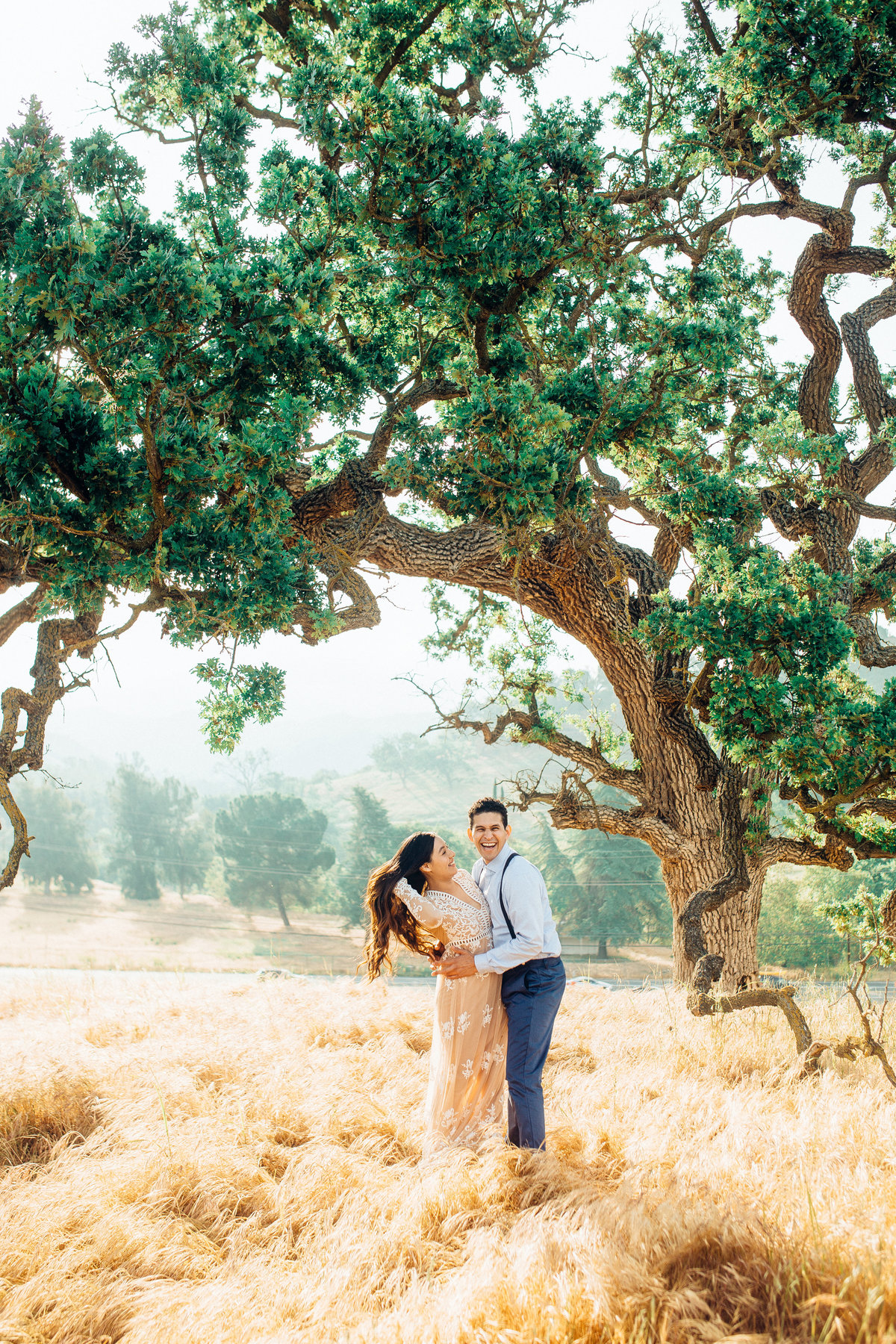 Engagement Photograph Of  Man Holding a Woman In Her Waist Beside a Tree Los Angeles