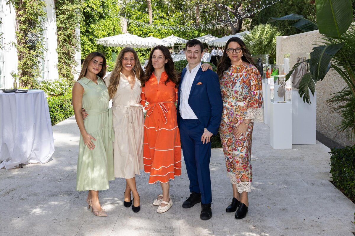 Group of hosts pose outdoors in stylish attire