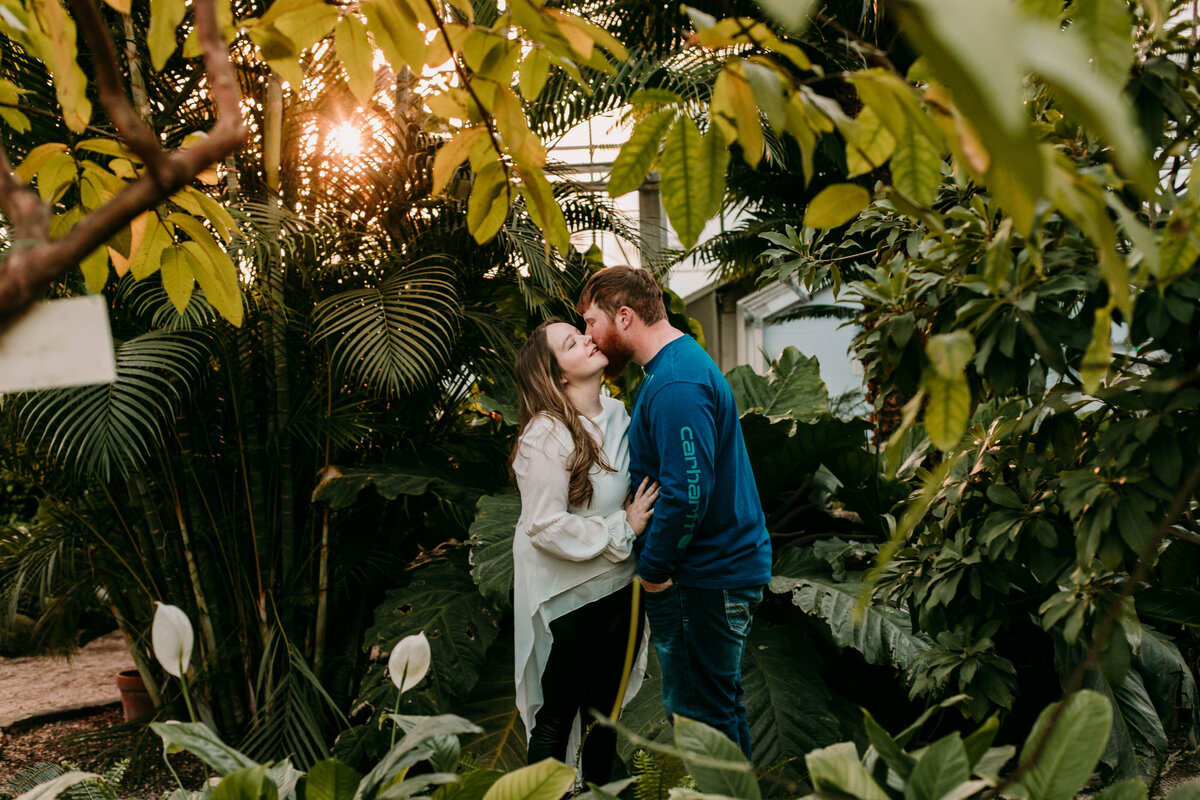 engaged man and woman kiss in birmingham botanical gardens alabama
