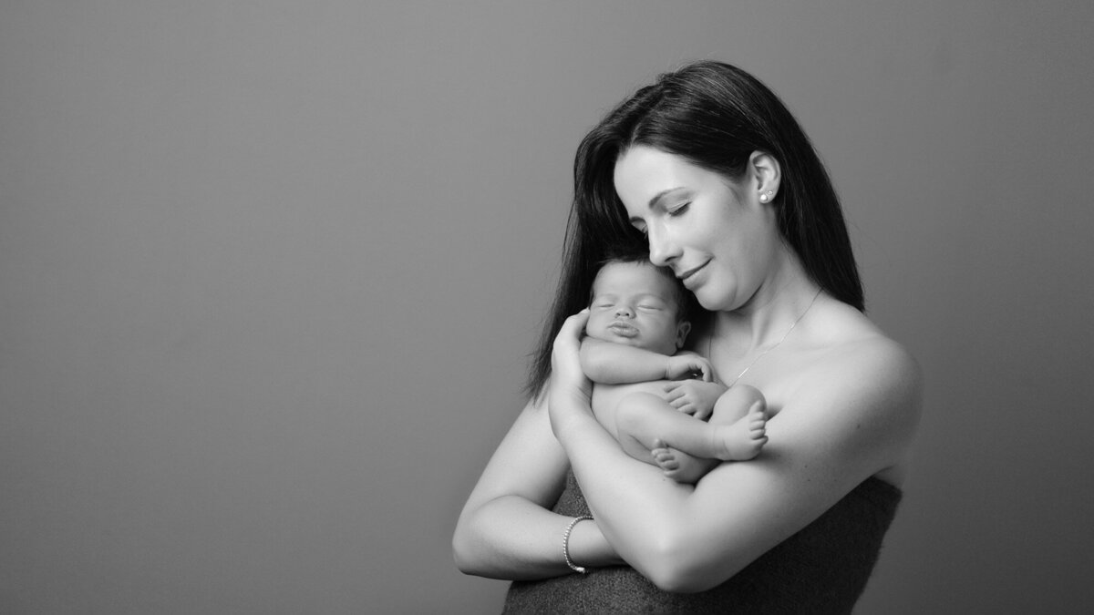 Mopther holding newborn baby during portrait session