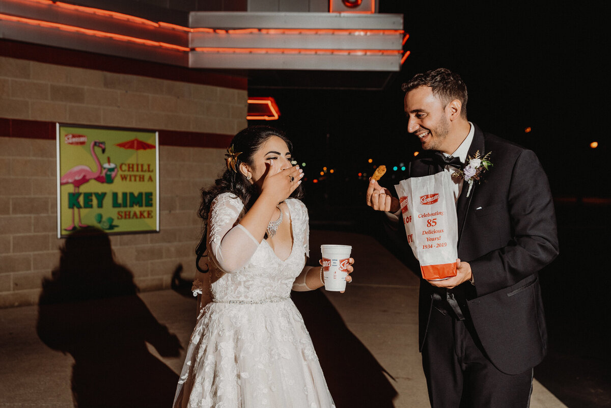 Couple snacks on Swensons food after wedding at night