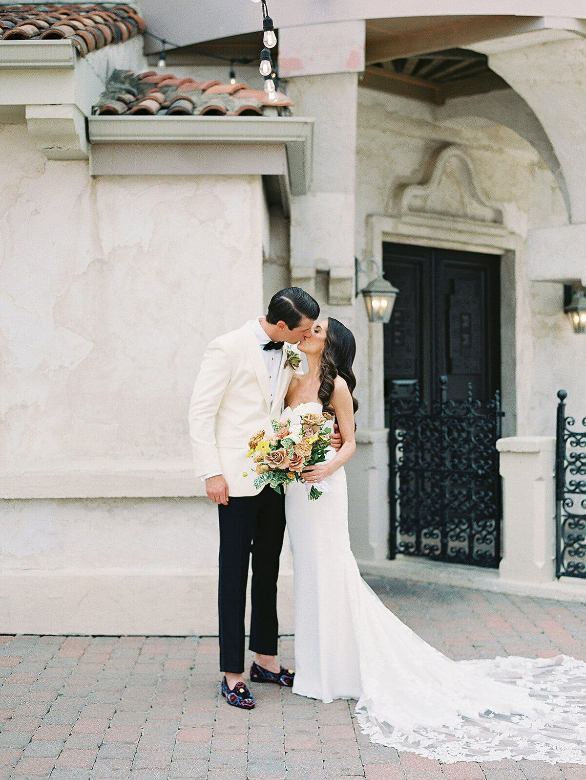 The bride and groom kiss for a classic photo at Villa Antonia