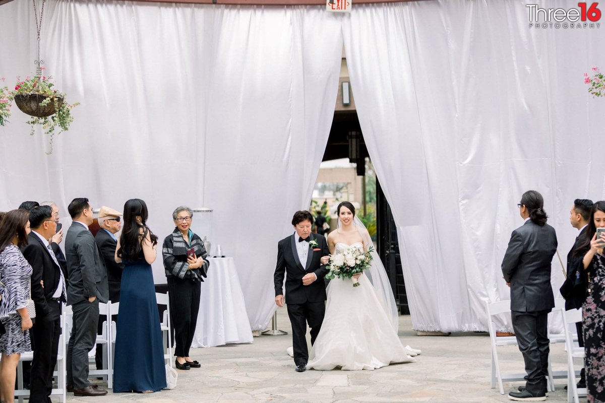 Bride and her father enter the wedding ceremony through drapes
