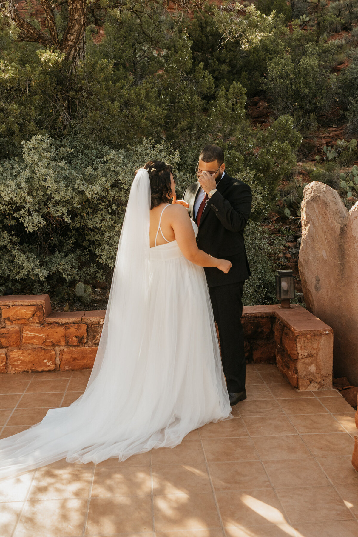 A person covering their face and crying during their first look at their wedding 