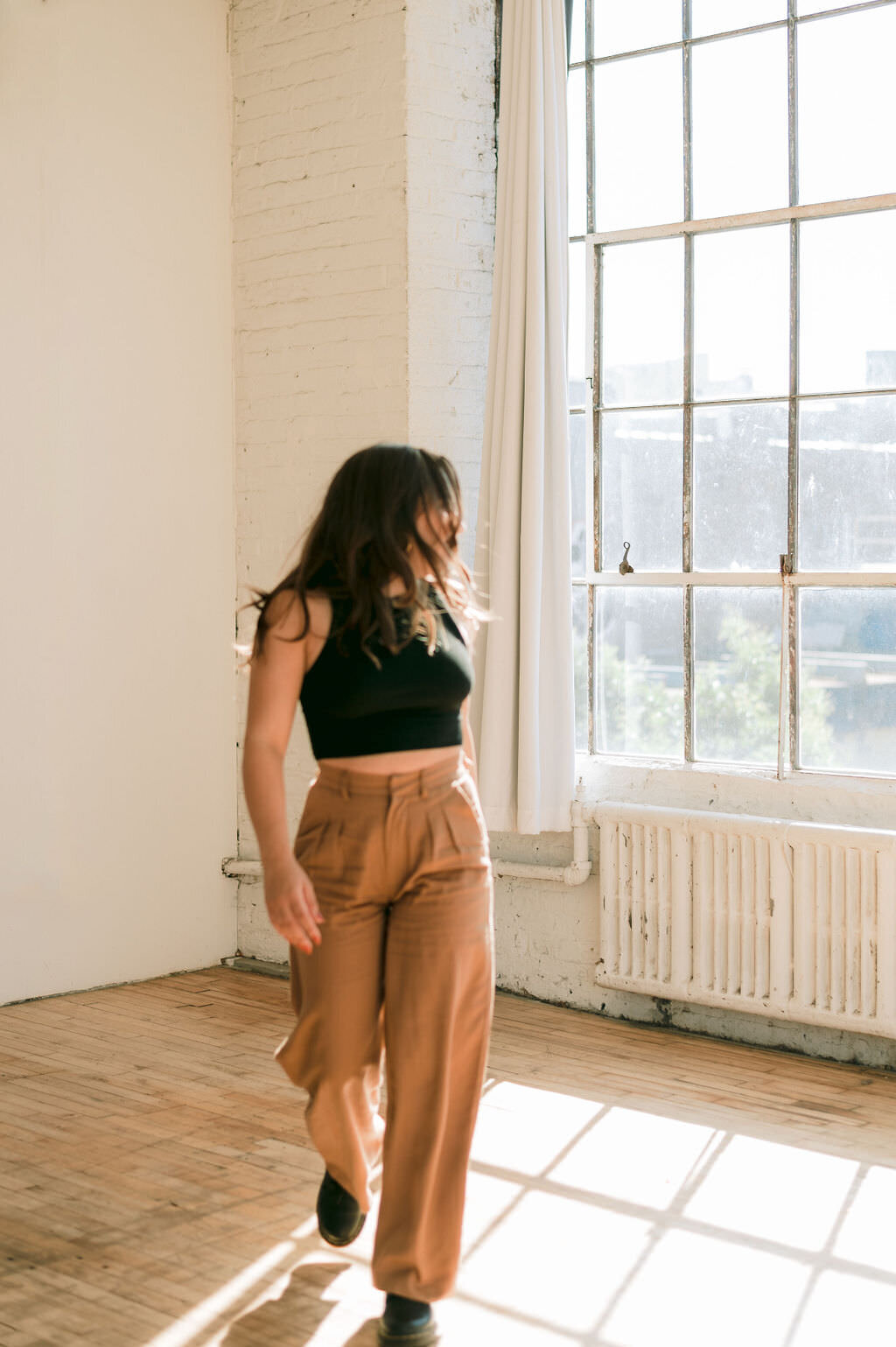 woman walking in an empty room looking back over her shoulder