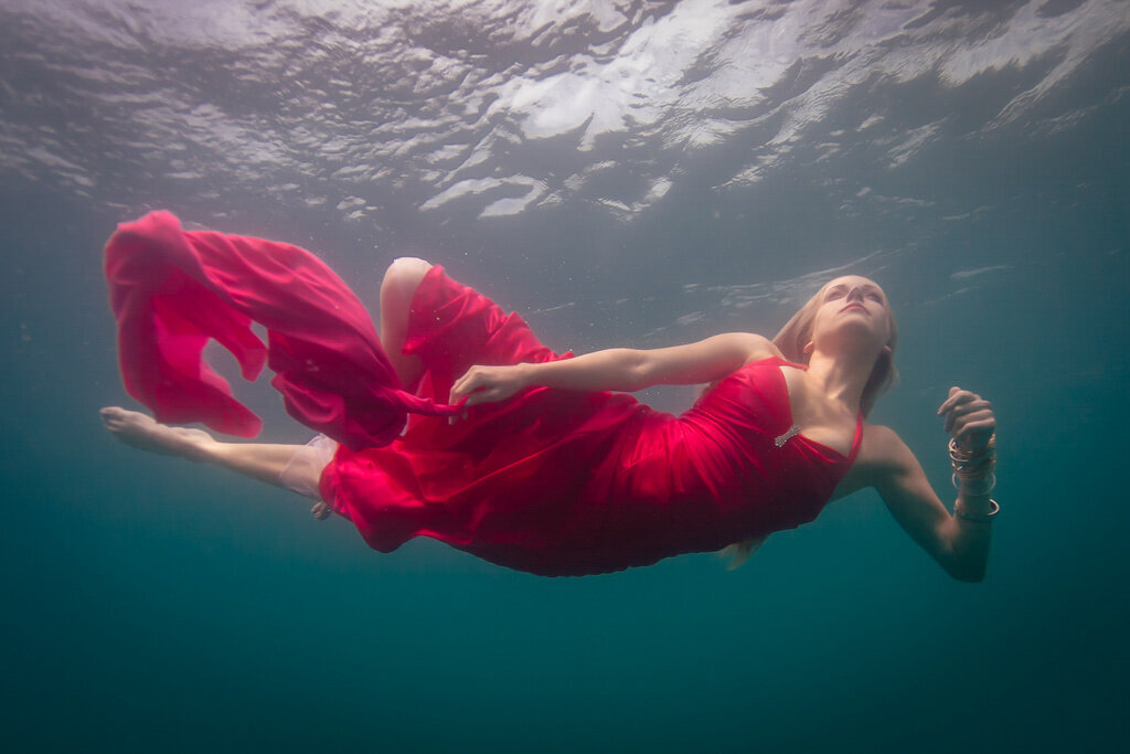 woman in red dress swimming underwater