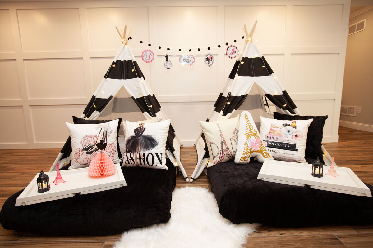 two teepee beds with paris fashion themed pillows and decor