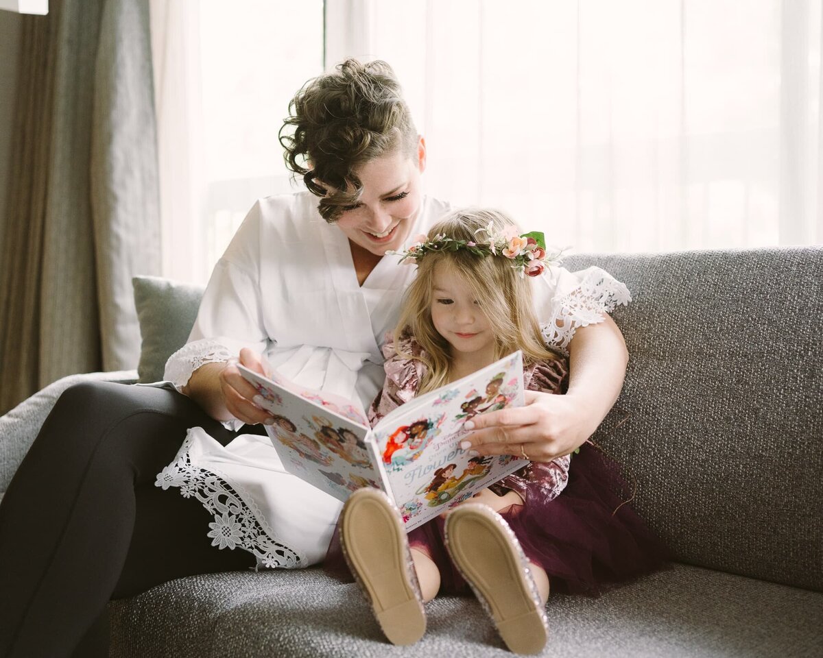 bride and flower girl reading a storybook together