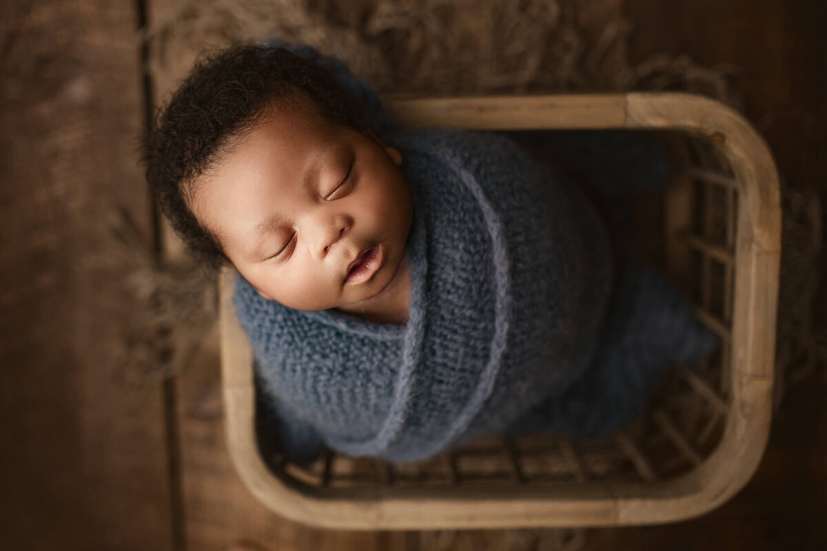 baby posed in basket