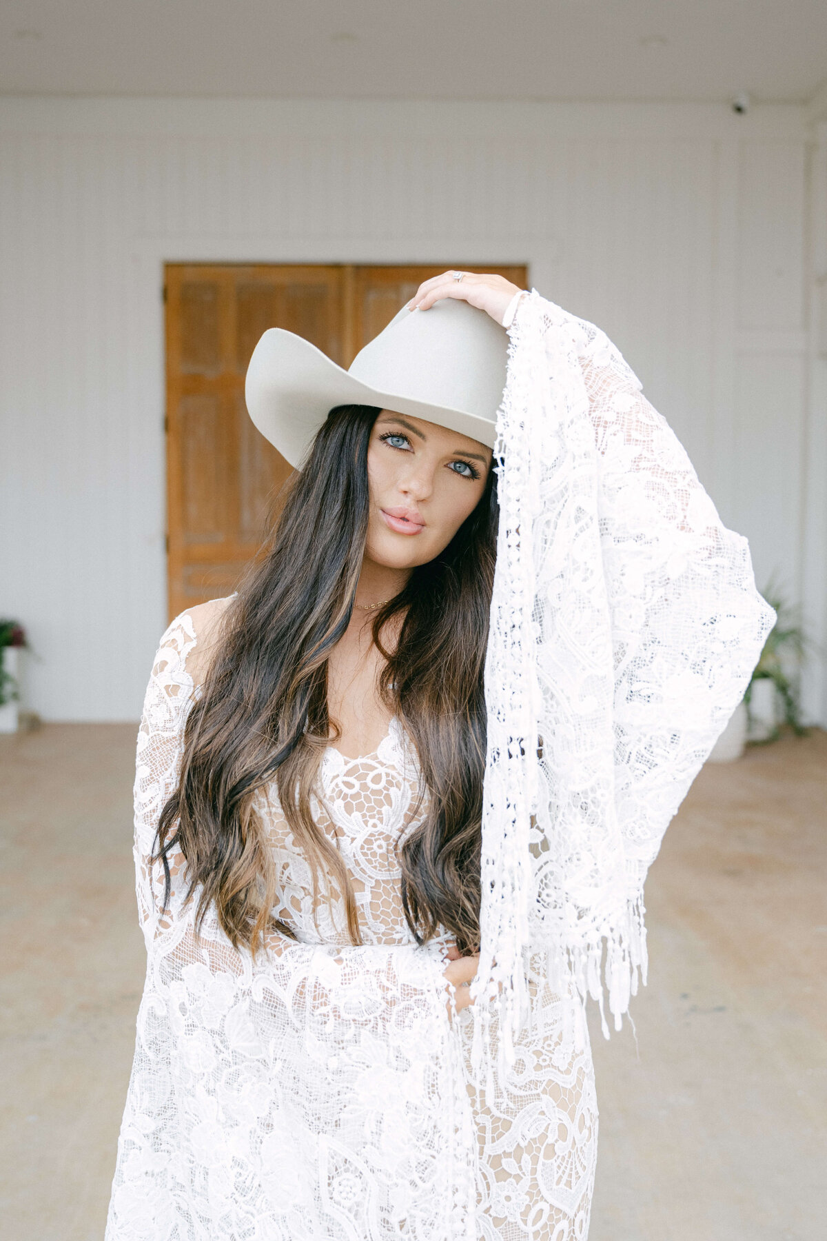 Close-up portrait of bride in a lace gown and wide-brimmed hat taken at The Videre Estate by Austin wedding photographer Erin Marcin.