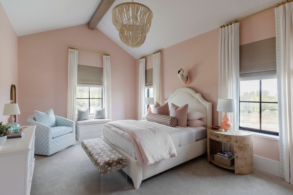 oyster creek studios hughes pink bedroom fwith white bedspread and gold chandelier