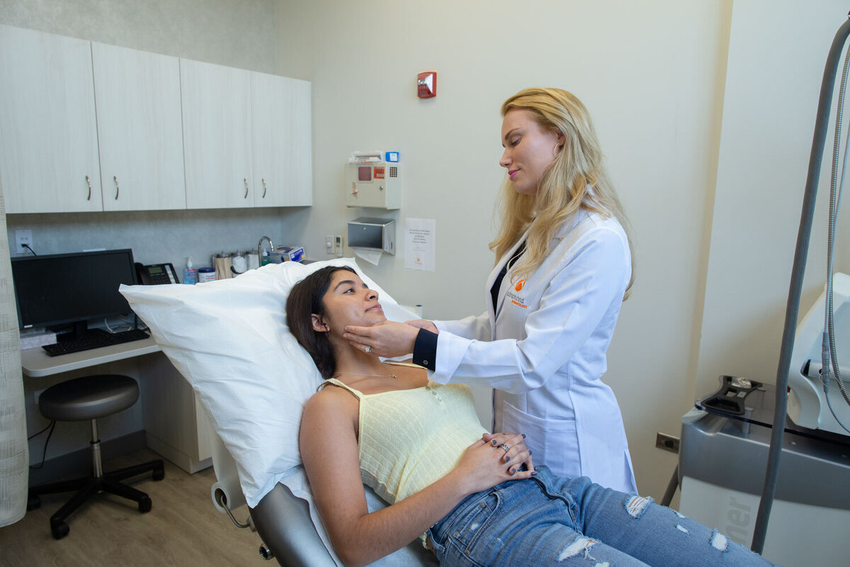 A woman in a hospital bed is being examined by a doctor