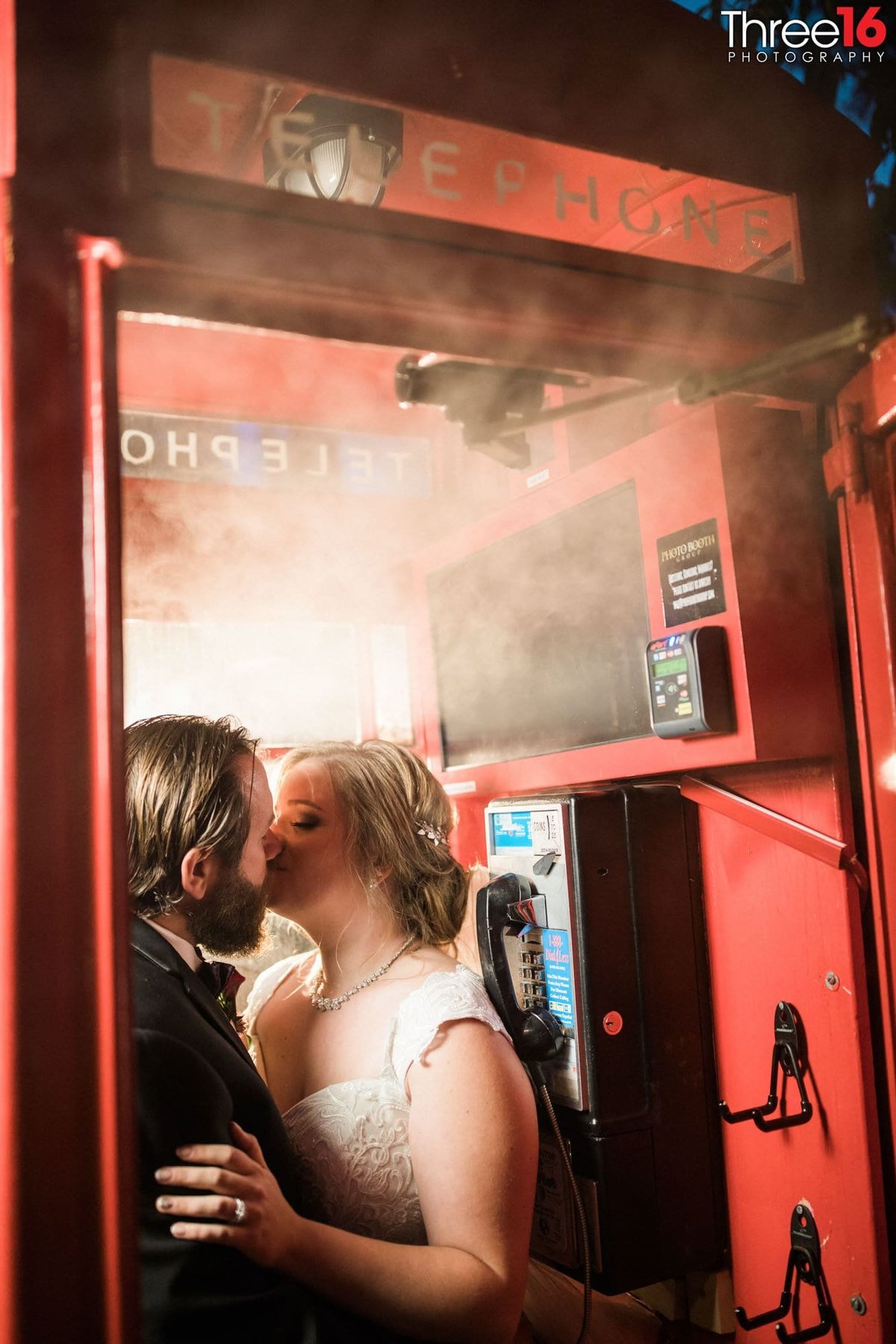 Bride and Groom share a steamy kiss in an old telephone booth