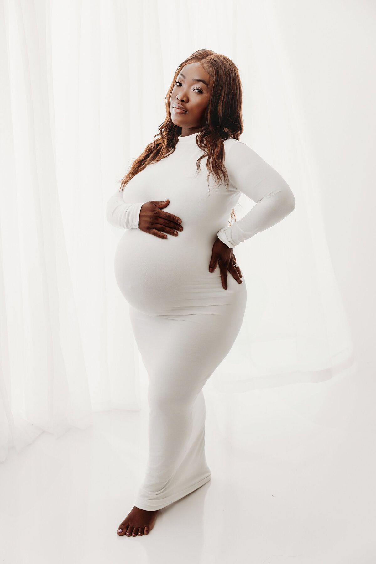 black pregnant woman posing in white dress for phoenix maternity session 