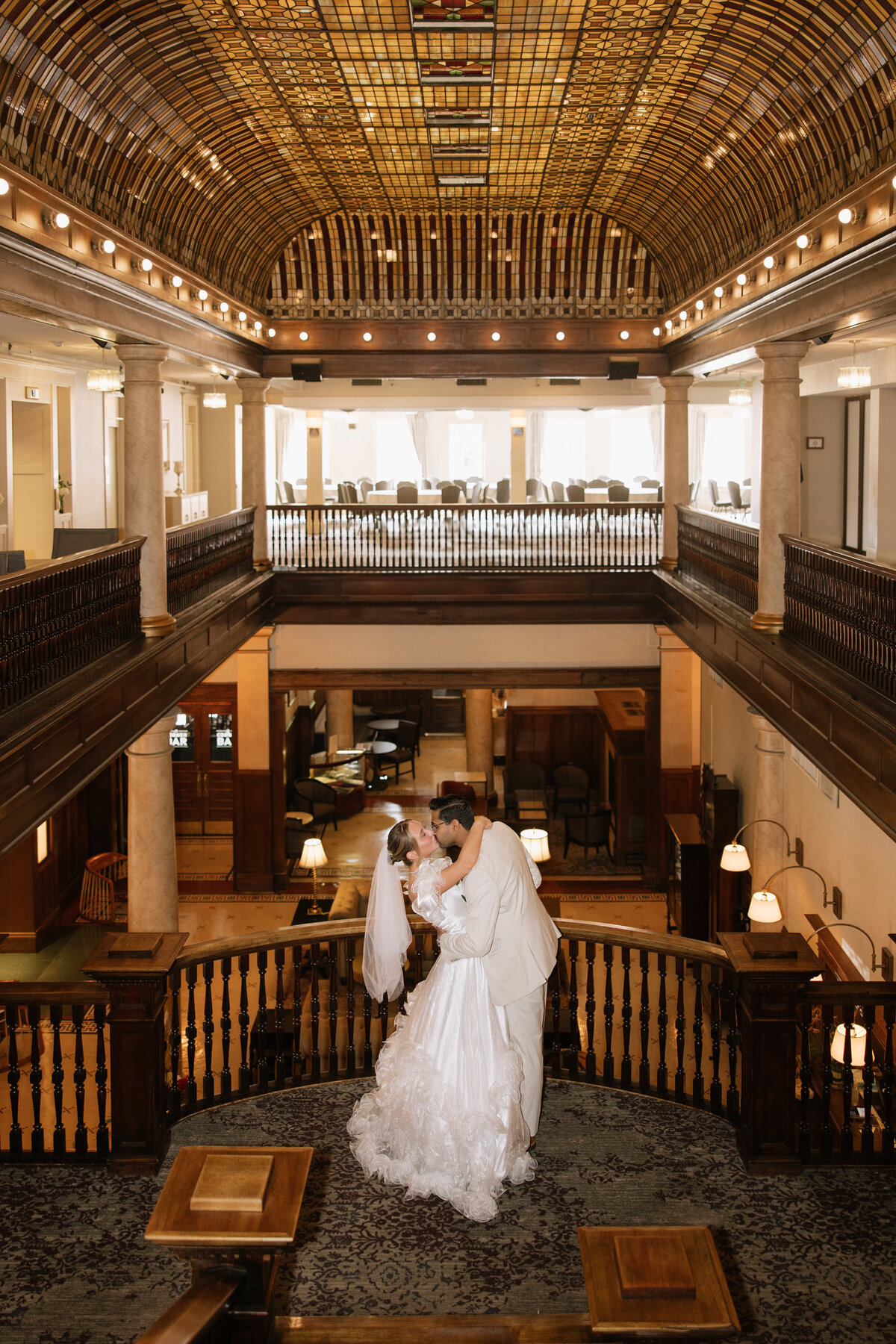 A bride and groom kiss in the hotel lobby of Hotel Boulderado during their wedding in Boulder, Colorado.