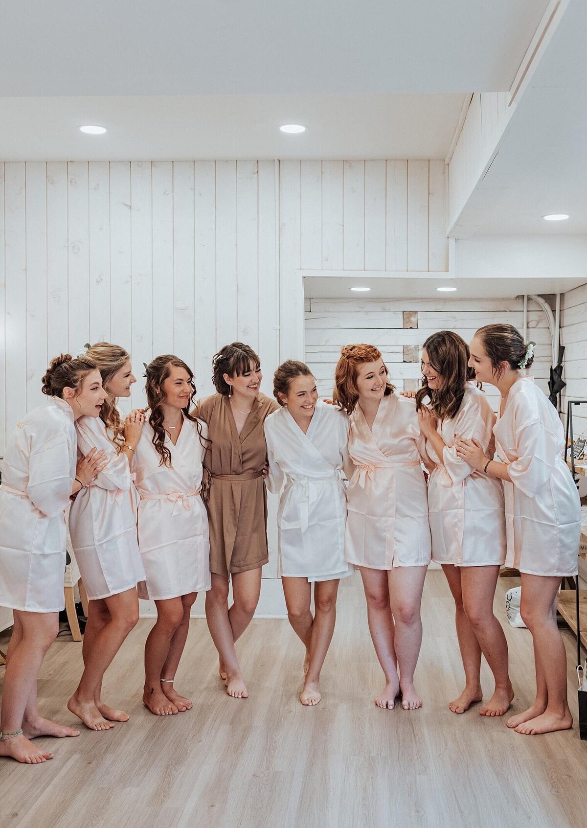 Bridal party in silk robes looking at each other smiling