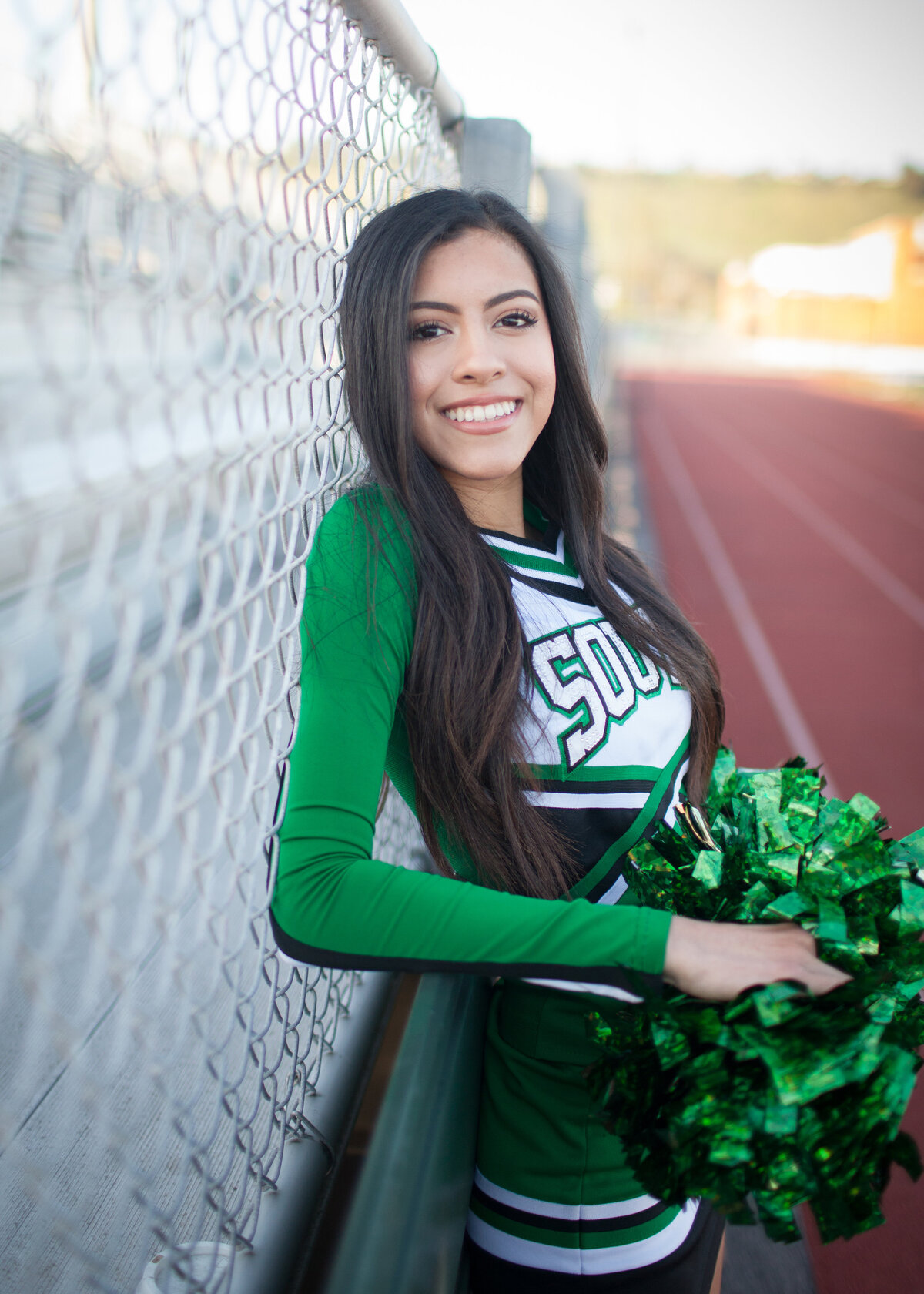 high-school-cheerleader-football-fence-pom-poms