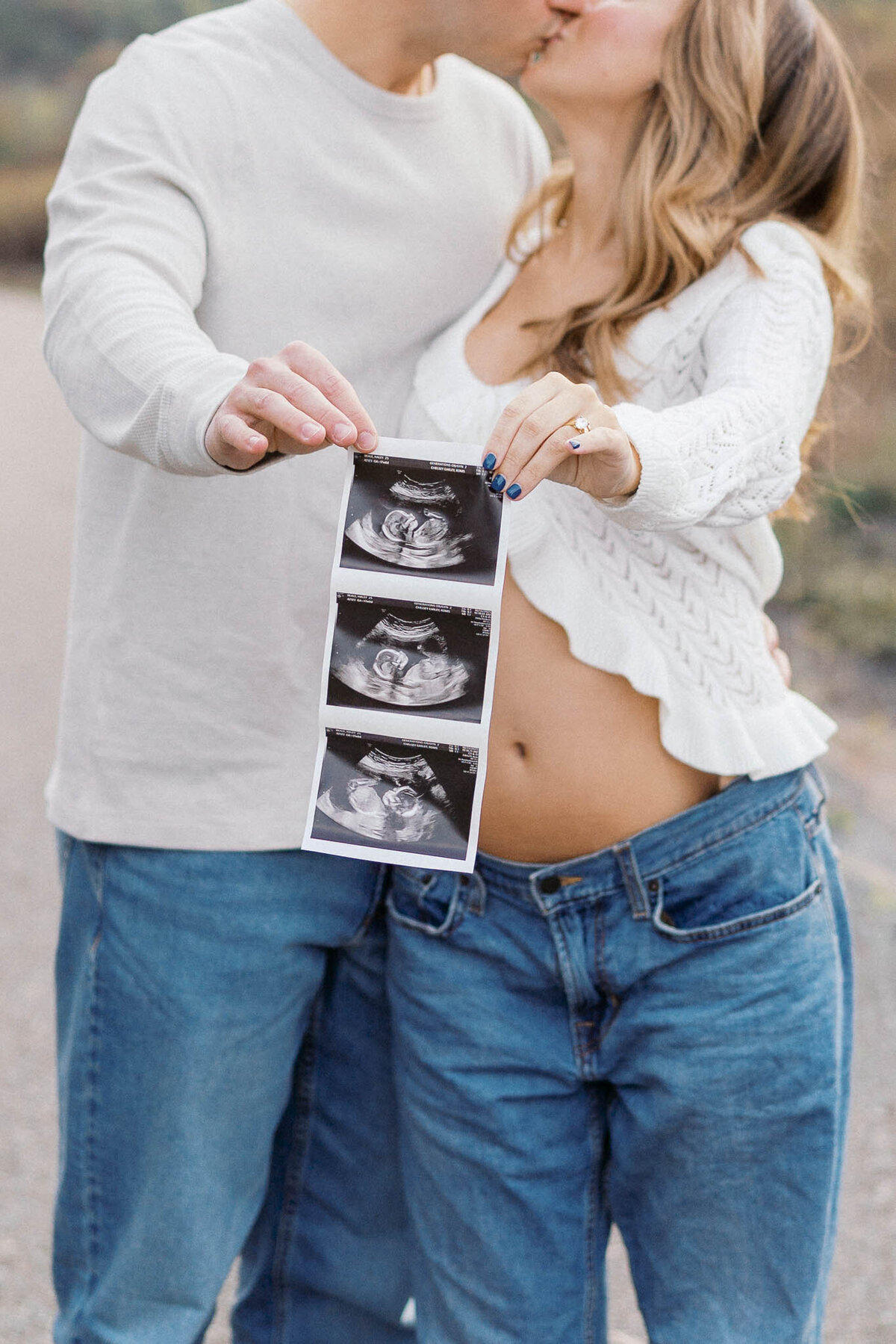 man and pregnant woman hold ultrasound outside at seven islands bird park in kodak tennessee