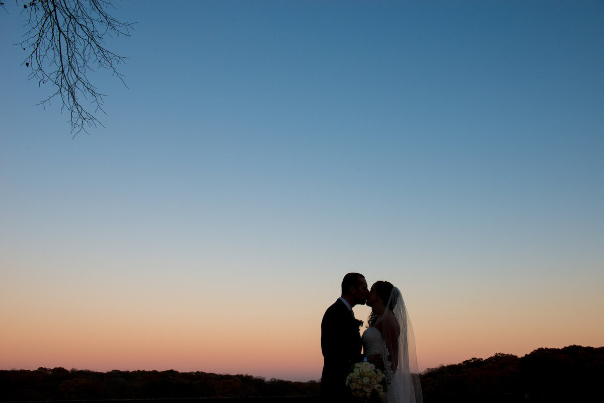 bride and groom kissing at sunset at Heritage Club at Bethpage