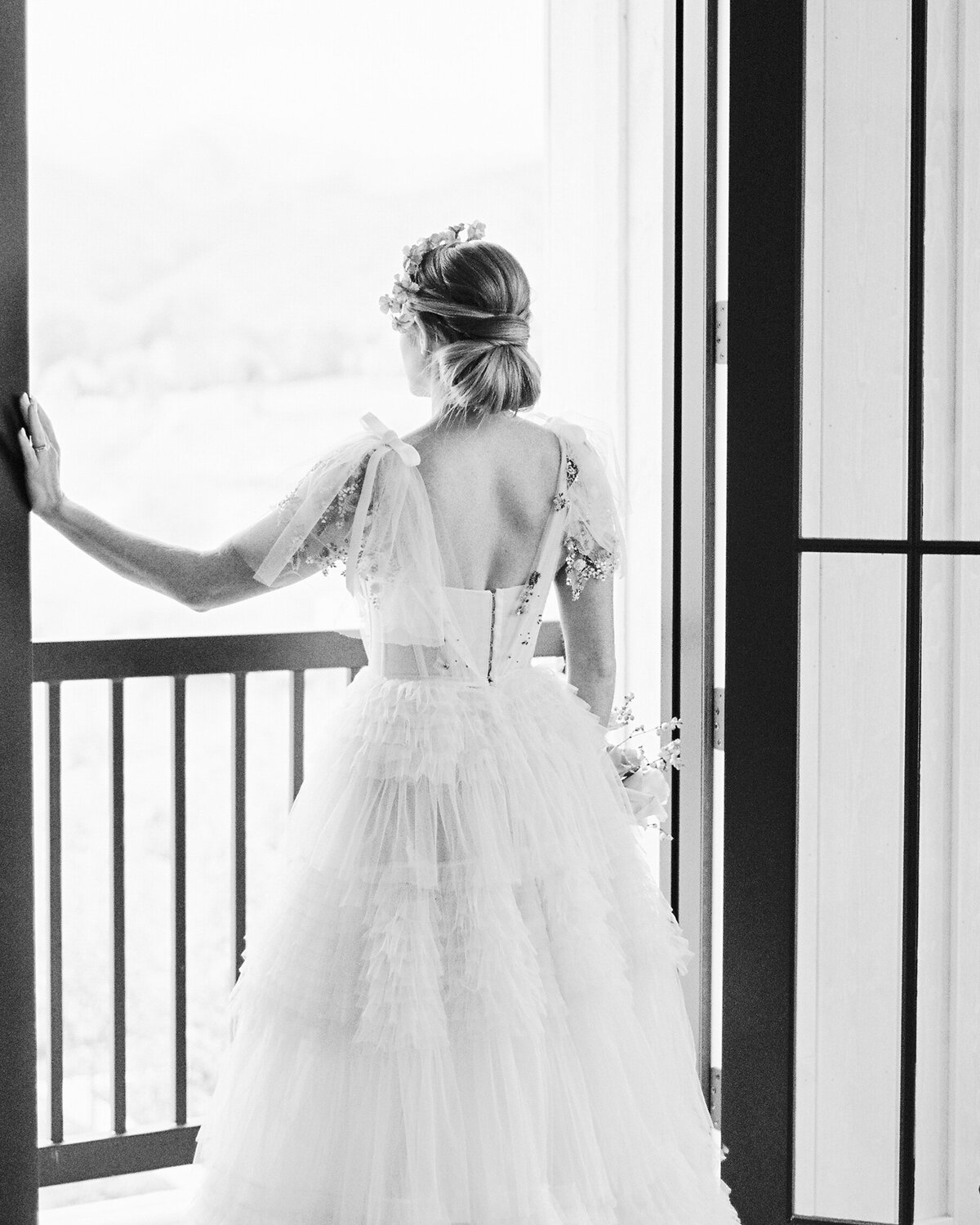 Bride looks outside the window on a balcony