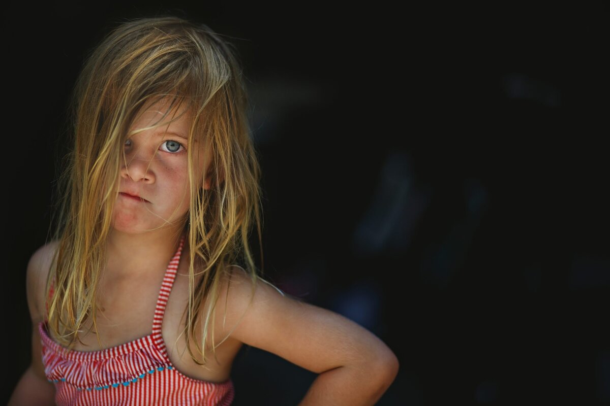 A bossy and angry looking child stares at the camera.