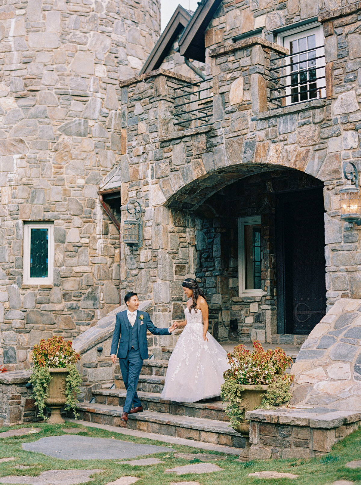 Bride and groom walking down the stone steps of Castle Ladyhawke during romantic portrait session.