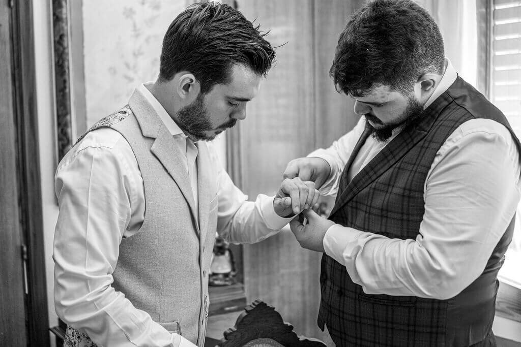 Best man helping groom get ready at home in Madrid