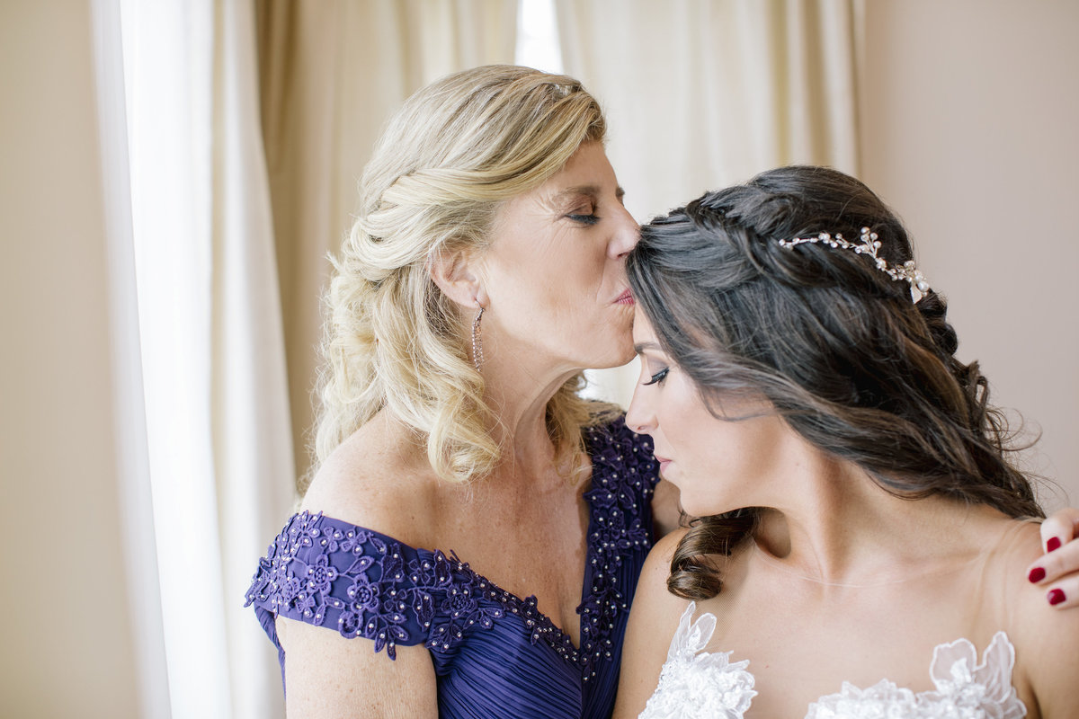 mom kissing brides head before wedding at the shadowbrook at shrewsbury