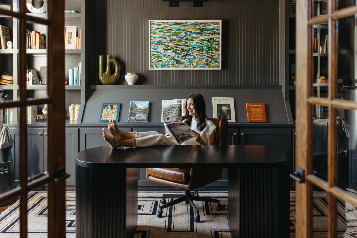 Hope Danyla sitting in a dark office interior designed by Hope Miriam Designs in DFW